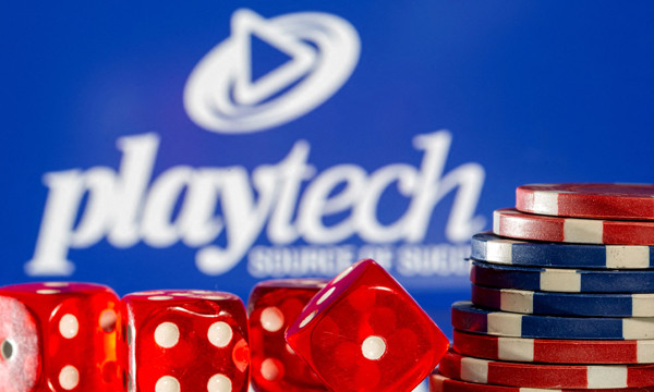 FILE PHOTO: Gambling cubes and chips are seen in front of displayed Playtech logo in this illustrati