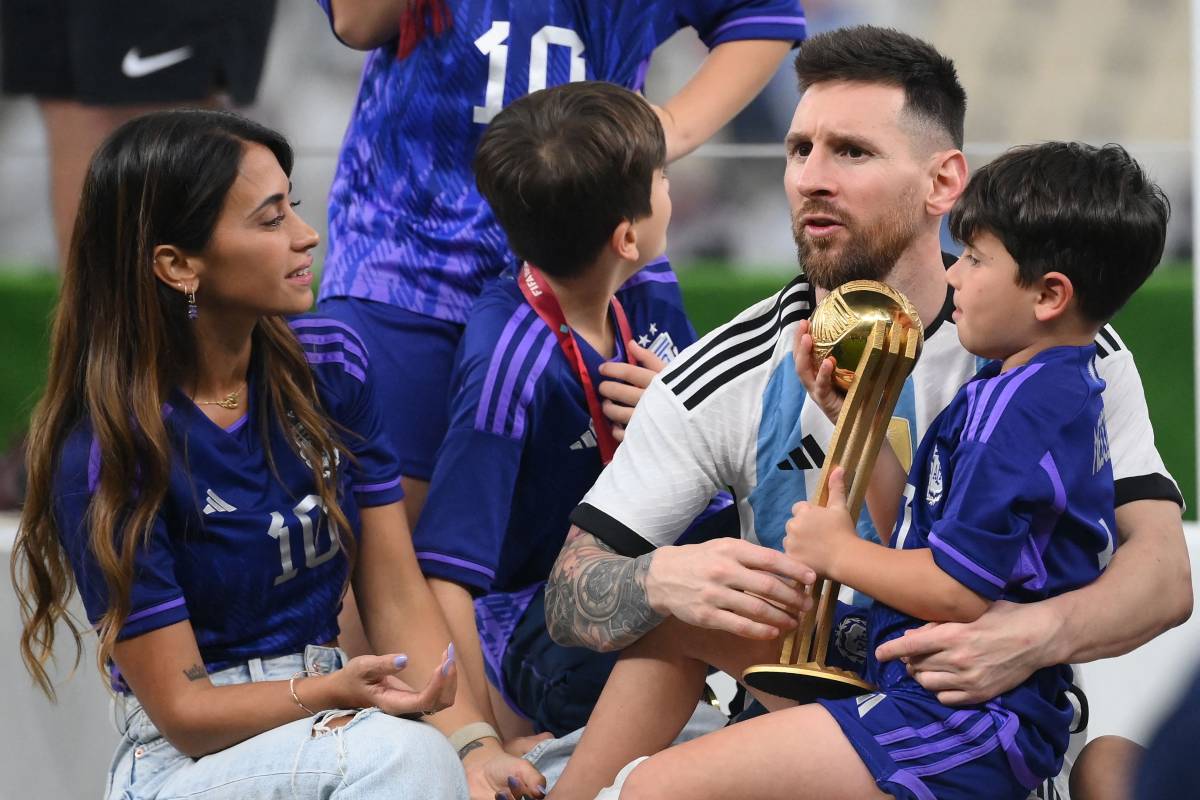 梅西（右）拿著金球獎座抱著兒子，與身旁的妻子享受榮耀的一刻。（AFP） 